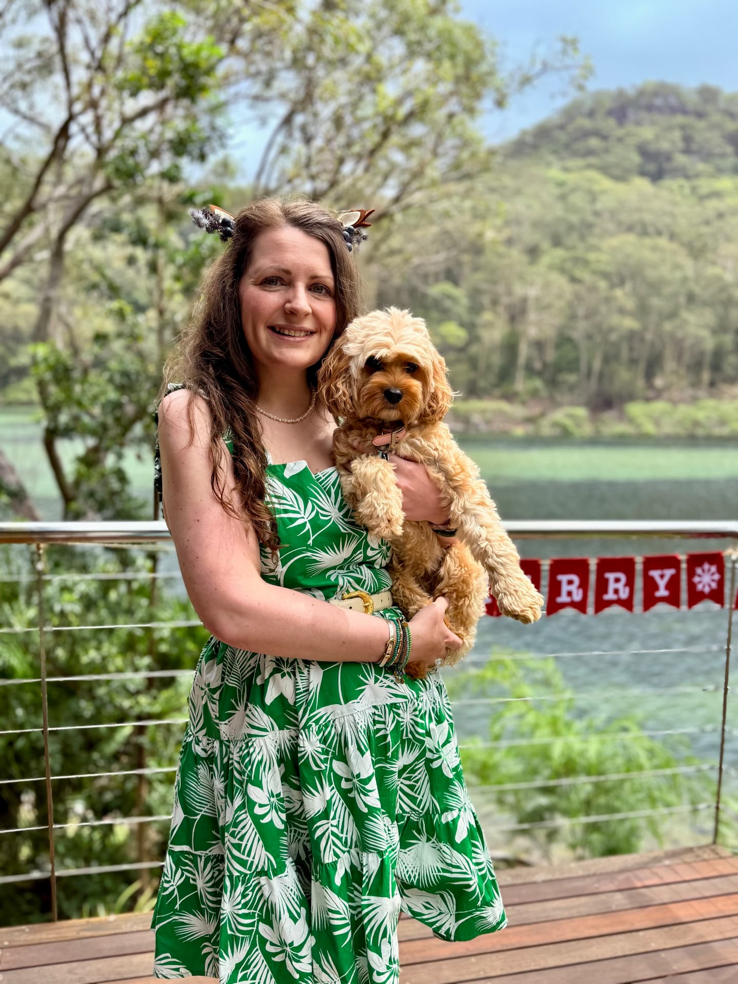 Jade Armstrong holding Bronte beside a tree-lined lake